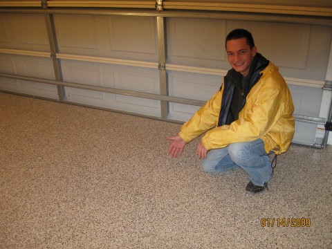 Man in a yellow jacket by a garage door and flake floor